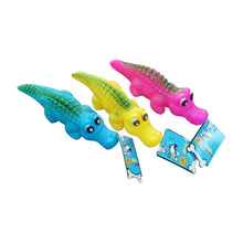Three colorful squeaky crocodile dog toys in blue, yellow, and pink rubber, featuring cartoonish eyes and textured backs.