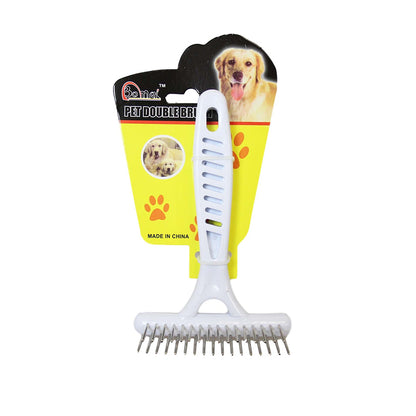 A metal teeth grooming brush for pets with a white plastic handle, packaged with a colorful backing displaying paw prints.